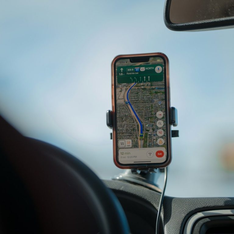 Ein Smartphone im Auto zeigt eine Kartennavigation auf dem Bildschirm.